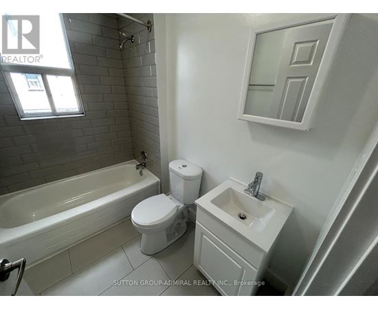 A white toilet and sink in a bathroom.