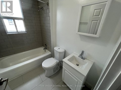 A white toilet and sink in a bathroom.