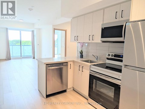 A modern kitchen with white cabinets and stainless steel appliances.