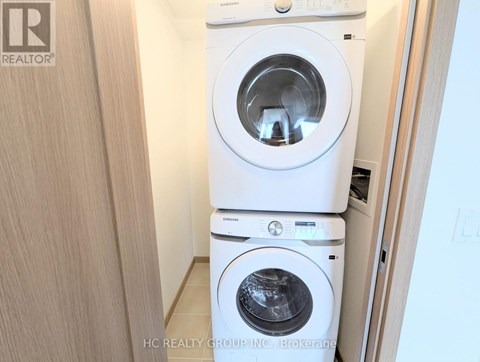 A white washing machine and dryer stacked on top of each other in a small room.