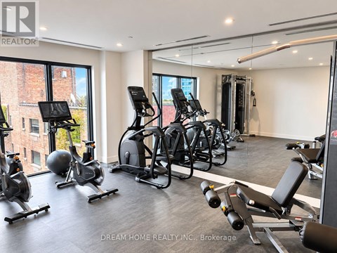 A gym with a row of treadmills and elliptical machines.