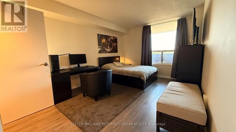 A bedroom with a bed, desk, and chair.