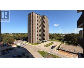A tall residential building with a parking lot in front.