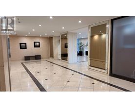 A spacious lobby with marble floors and a glass wall.