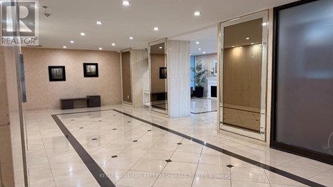 A spacious lobby with marble floors and a glass wall.