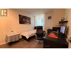 A bedroom with a bed, desk, and chair.