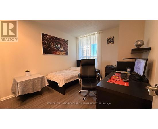 A bedroom with a bed, desk, and chair.