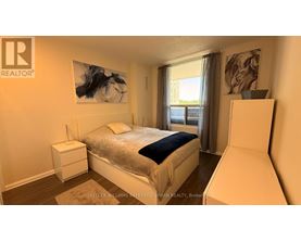A bedroom with a large bed and a painting on the wall.