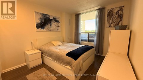A bedroom with a large bed and a painting on the wall.