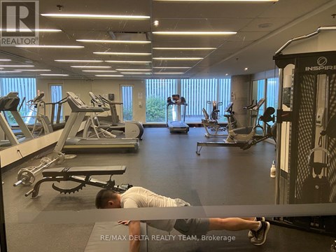 A man is working out in a gym with a variety of equipment.