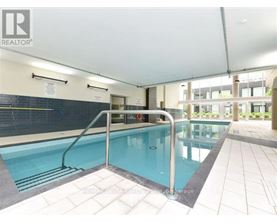 A large indoor swimming pool with a diving board.