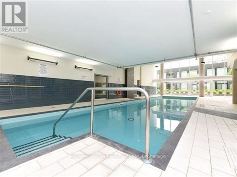A large indoor swimming pool with a diving board.