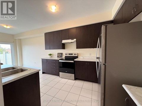 A kitchen with brown cabinets and a white fridge.