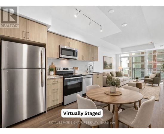 A modern kitchen with a stainless steel refrigerator and a dining table set for four.