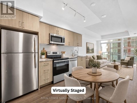 A modern kitchen with a stainless steel refrigerator and a dining table set for four.