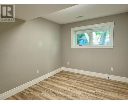 A room with a window and wooden flooring.