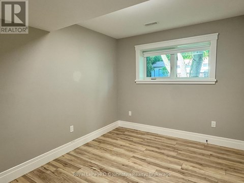 A room with a window and wooden flooring.