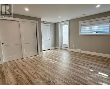 A room with wooden flooring and white walls.