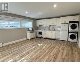 A kitchen with white appliances and wooden floors.