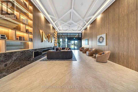 A modern lobby with a marble floor and wooden walls.