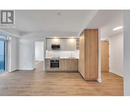 A spacious, well-lit kitchen with wooden cabinets and a built-in oven.