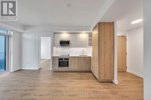 A spacious, well-lit kitchen with wooden cabinets and a built-in oven.