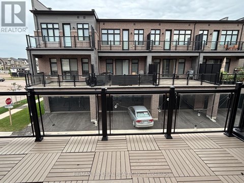 A car is parked in the driveway of a two-story residential building.