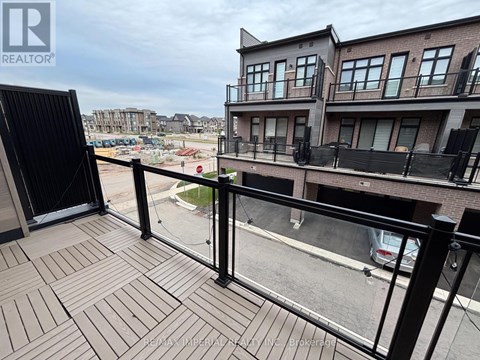 A balcony with a black railing and a wooden floor.