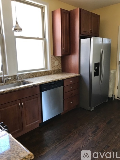 A kitchen with wooden cabinets and a stainless steel refrigerator.
