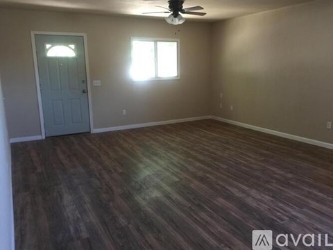 A room with a wooden floor and a ceiling fan.