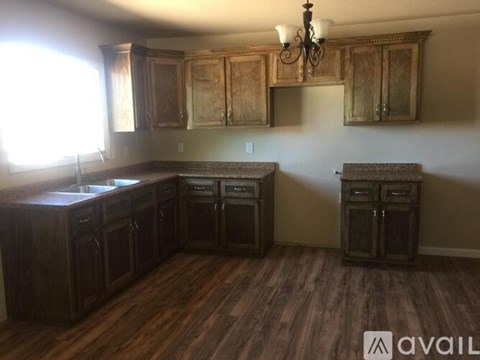A kitchen with wooden cabinets and a chandelier.