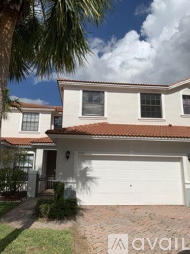A house with a white garage door and a red tile roof.