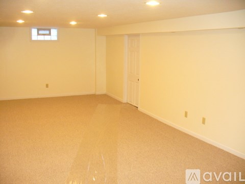 A room with a carpeted floor and a door.