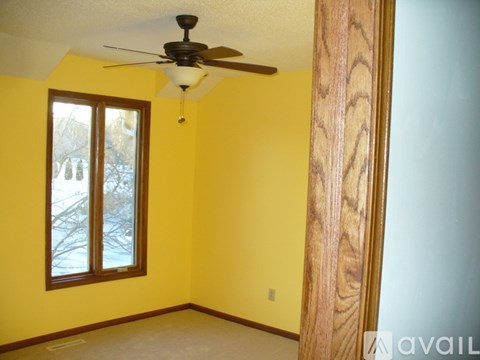 A room with a ceiling fan and a window.