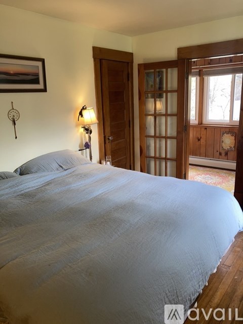 A bedroom with a large bed and a wooden door.