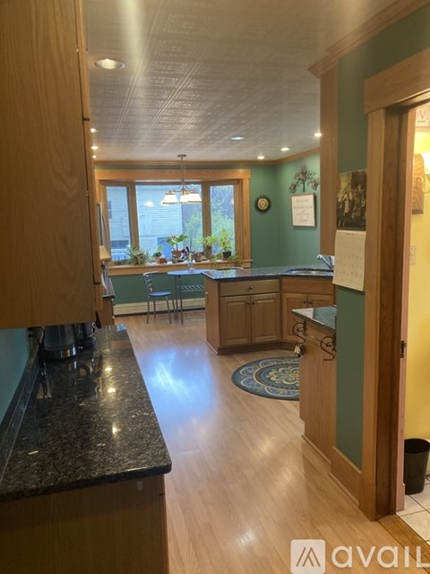 A kitchen with a black counter top and wooden cabinets.