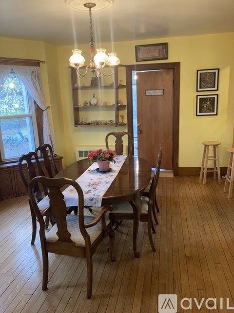 A dining room with a wooden table and chairs.