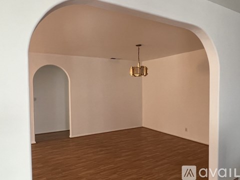 A room with a wooden floor and a hanging light fixture.