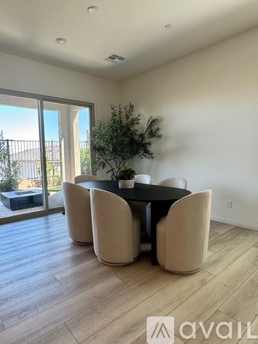 A dining room with a table and chairs and a plant.