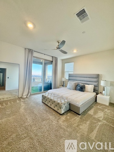 A bedroom with a large bed and a ceiling fan.