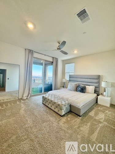 A bedroom with a large bed and a ceiling fan.