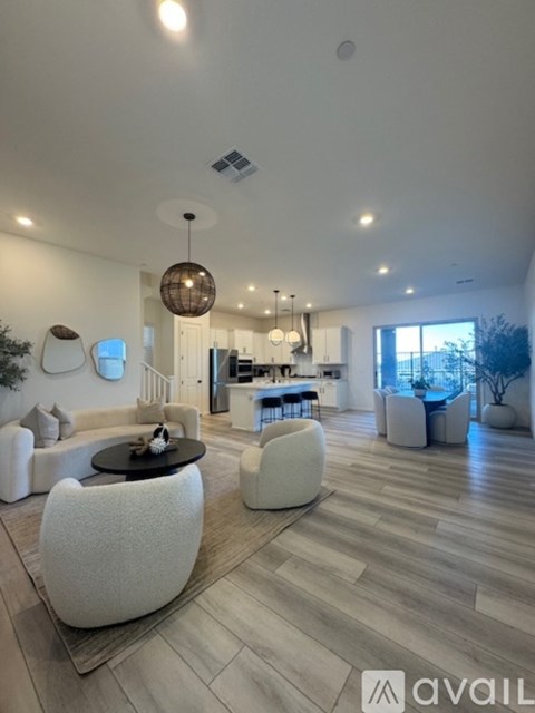 A modern living room with a white sofa set and a wooden floor.