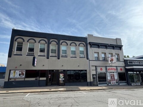 A street view of a building with a sign that reads "Alex's".