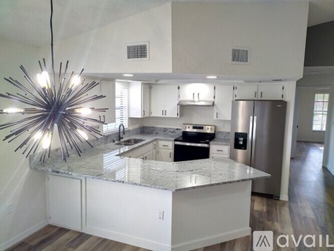 A modern kitchen with a large island and a central island light.