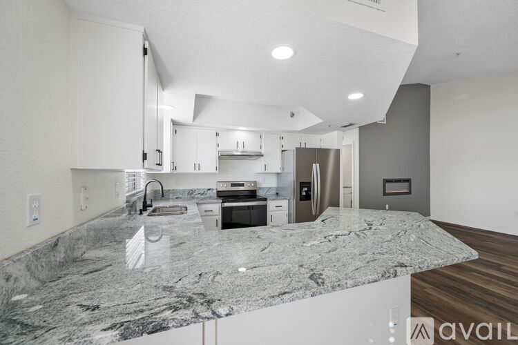 A modern kitchen with granite countertops and stainless steel appliances.