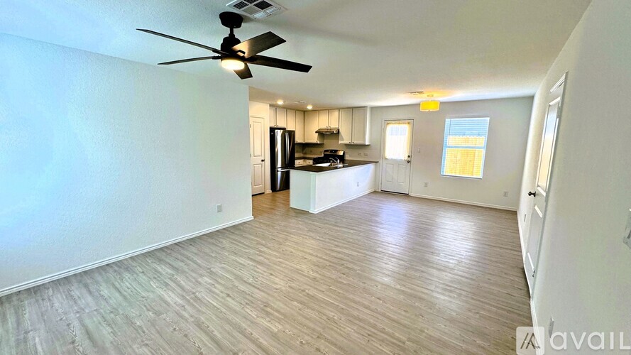 A room with a ceiling fan and wooden flooring.