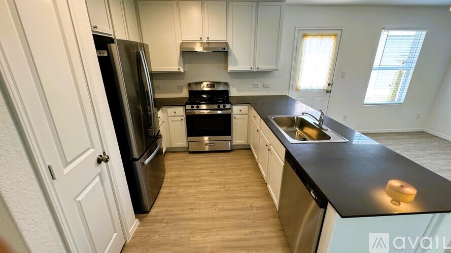A kitchen with a black countertop and stainless steel appliances.