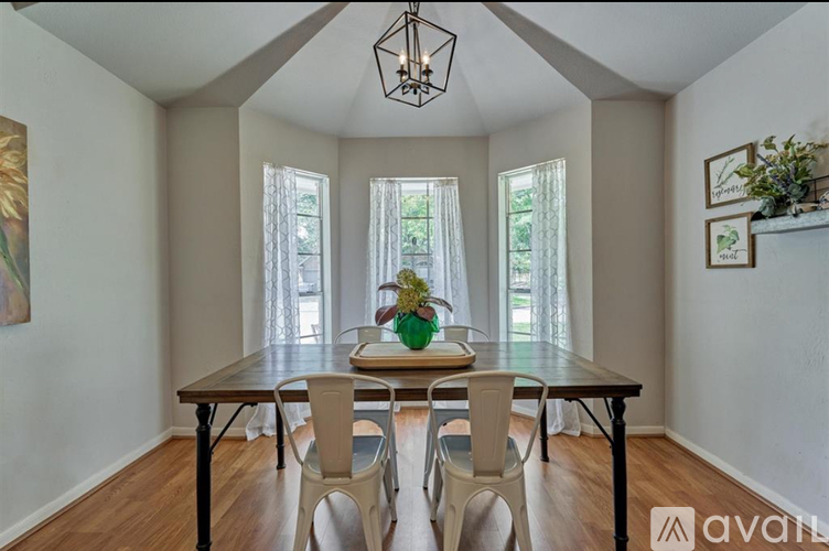 A dining room with a wooden table and chairs.