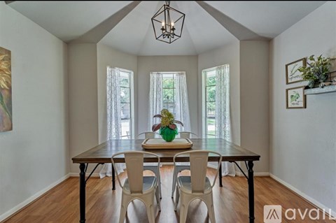 A dining room with a wooden table and chairs.