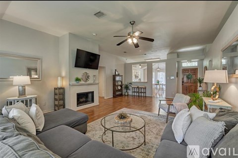 A living room with a grey couch and a fireplace.
